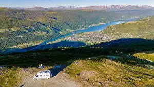 Travel Influencer Prints: A white campervan parked on a grassy hillside overlooking a stunning Norwegian fjord