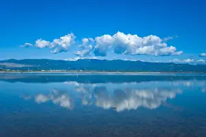 Stillness Prints: White clouds are mirrored on the calm blue surface of the Missolonghi salt marsh in western Greece