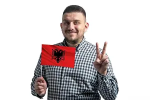Citizenship Prints: White guy holding a flag of Albania and shows two fingers isolated on a white background