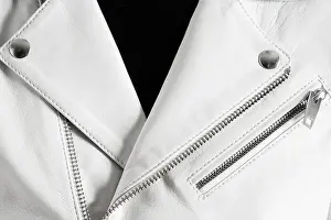 Zipper Prints: White leather jacket with metallic zippers and stitched pocket. Detailed closeup texture