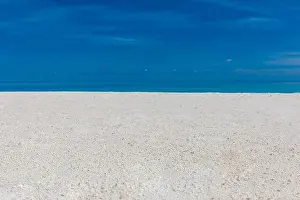 White sandy tropical beach and soft sunlight background and banner. Sea sand sky concept. Relaxing beach landscape, sunny view