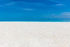 White sandy tropical beach and soft sunlight background and banner. Sea sand sky concept. Relaxing beach landscape, sunny view