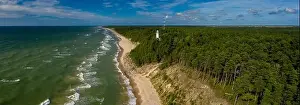 White Uzhava lighthouse on the shore of Baltic Sea. Sunny day