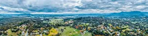 Rural Town Prints: Wide aerial panorama of scenic rural landscape with houses surrounded by forest and mountains