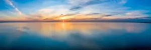 Moody Sky Prints: Wide aerial panorama of seascape - sunset reflecting in calm sea