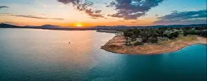 Wide aerial panorama of a tiny boat in big lake at sunset with copy space