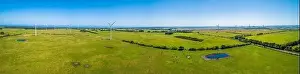 Wide aerial panorama of wind farm and grazelands on bright sunny day in Australia