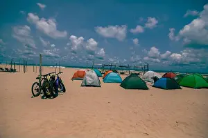 Outdoor Recreation Prints: Wide-angle view of a colorful beach campsite on a large sandy beach beside the ocean