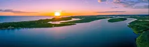 Wide minimalist aerial panorama of sunset over ocean coastline