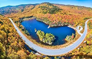 New Hampshire Prints: Wide panorama aerial over highway through stunning peak fall foliage New Hampshire mountains around blue lake