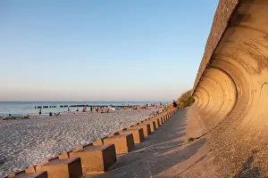 Wide view of a yellow beach full of relaxed people swimming on a clear sea