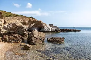 Pebble Prints: Wild pebble beach on mediterranean sea with rocky cliffs shore and blue clear water