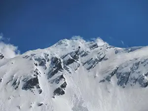 Winter in the rocky mountains covered with snow against blue sky with small clouds