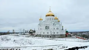 Temple Building Prints: Winter view. Clip. Snow strewn on the road and a large white Orthodox church with golden domes