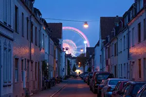 Wohnhaeuser in Findorff und Riesenrad vom Bremer Freimarkt bei Abenddämmerung