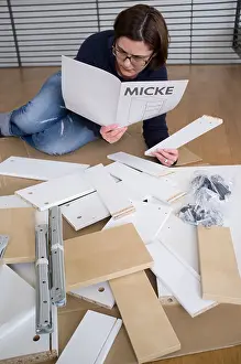 Instructions Prints: Woman assembling flat-pack furniture from IKEA at home