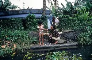 In Water Prints: A Woman Bathing her daughter, Backwaters of kerala. Mother & child
