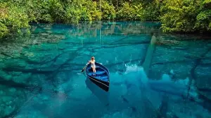 Banggai Prints: Woman on boat floating in tropical transparent lake with crystal blue fresh water in Sulawesi