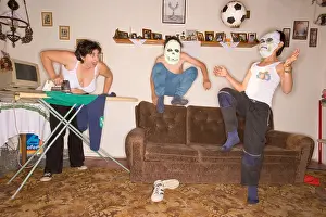 Knees Prints: Woman in bra ironing and watching two boys playing football inside the room