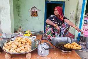 Hindi Prints: A woman cooking samosas and chilli pakora at food hotel in Varanasi, India