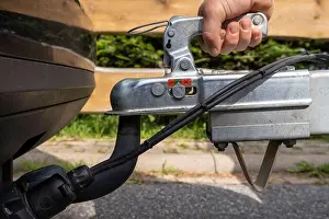 Attached Prints: woman couple a trailer (i.s. hooked) into a ball-type tow hitch