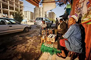 Addis Ababa Prints: A woman cultivates the Ethiopian coffee tradition in her street bar in a development area