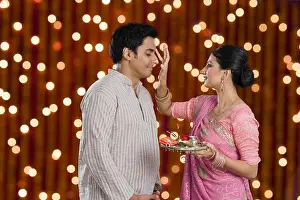Young Couple Prints: Woman doing tilak of her husband on Diwali