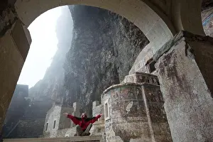 Lotus Position Prints: Woman dressed in red clothes meditates in Sumela Monastery (Turkey)