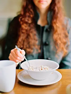 Redhead Prints: A woman eating breakfast cereal from a white bowl