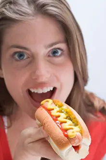Grown Up Prints: Woman eating a hot dog with mustard -