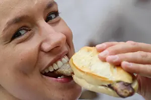 A woman eats bratwurst during the First Franconian Bratwurt summit meeting in Pegnitz