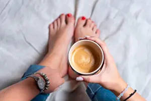 Wake Up Prints: Woman enjoys cup of coffee at home wearing jeans top closeup view