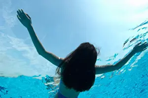 Leisurely Prints: Woman floating in swimming pool, underwater view