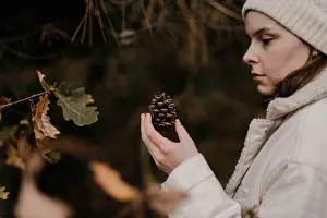 Conifer Prints: A woman hold a pinecone in her hand