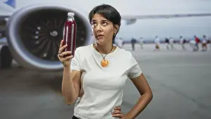Well Being Prints: Woman holding a bottle of pomegranate juice with hand on hip