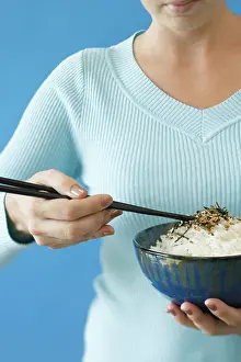 Midsection Prints: Woman holding bowl of rice in one hand and chopsticks in the other