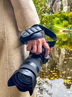 Water Reflection Prints: Woman Holding Camera with Telephoto Lens Outdoors Near Water