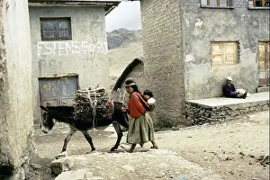 Desolate Prints: WOMAN HOLDING A CHILD ON HER BACK WALKING WITH A DONKEY LOADED WITH FIREWOOD ACROSS A VILLAGE BOLIVIA
