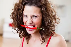 Frowning Prints: Woman Holding Chili With Teeth
