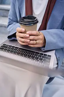Knees Prints: Woman holding coffee and laptop in her hands