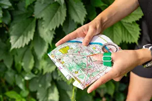 Compass Prints: Woman holding a map and the compass during orienteering competitions