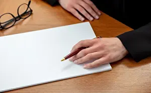 Woman holding a pen on a blank white paper
