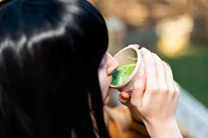 Tasting Prints: Woman holding tea cup face closeup drinking outside in backyard garden with girl and green matcha black hair