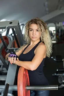 Bodybuilding Prints: Woman with long blonde curly hair - portrait of a fitness trainer in the gym