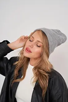 Headwear Prints: A woman with long blonde hair wearing a gray beanie and black jacket poses with closed eyes