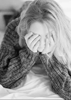 Bedsheet Prints: Woman lying on bed, leaning on elbows, hands over face, black and white