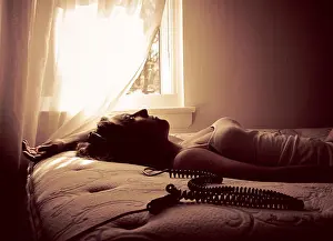 Contentment Prints: Woman lying on bed listening to music with headphones