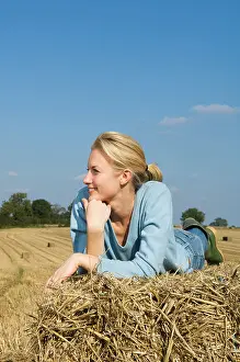 Only Women Prints: Woman lying on hay bale
