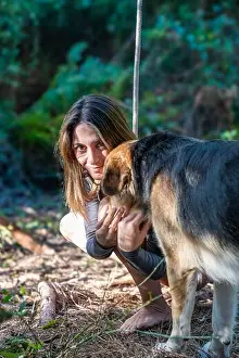 Barefoot Prints: Woman petting dog outdoors in the forest