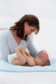 Affectionate Prints: Woman placing her hand on the forehead of a baby lying on its back